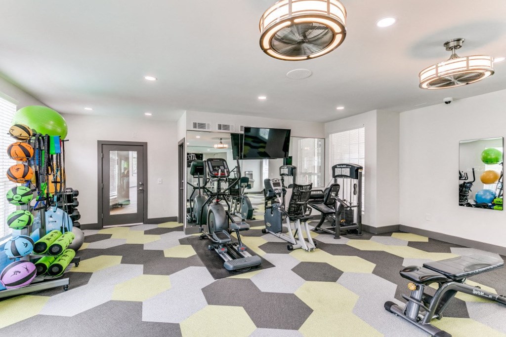 a home gym with weights and a tv on the wall