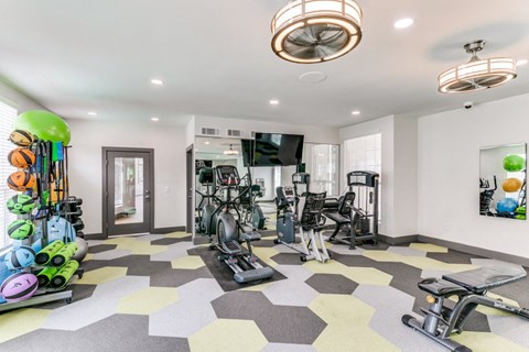 a home gym with weights and a tv on the wall