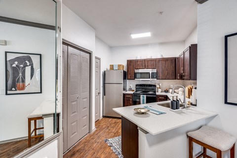 a kitchen with a white counter top and a stainless steel refrigerator