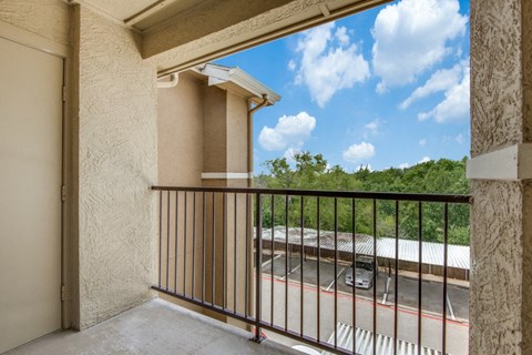 a balcony with a view of a building and a train yard