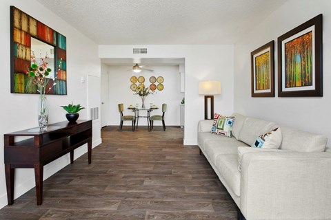 A living room with a white couch and a wooden table.