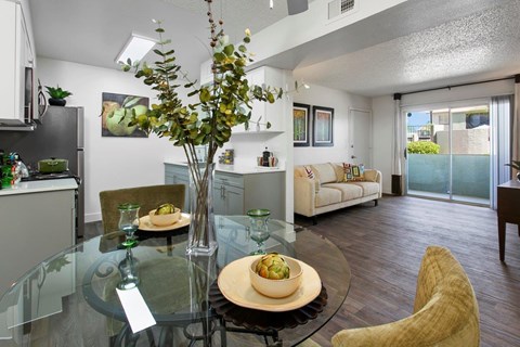 A modern dining room with a glass table and chairs.
