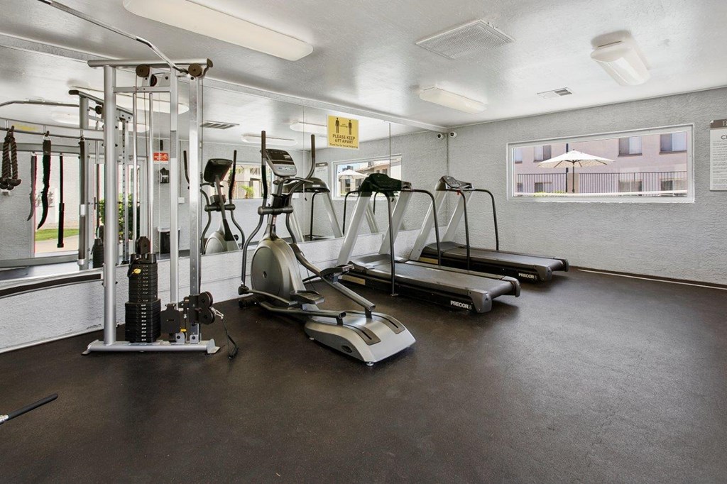 A gym with treadmills, elliptical machines, and other exercise equipment.