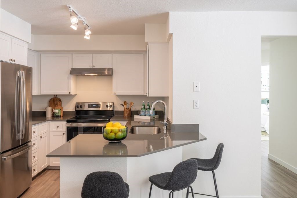 A kitchen with a table and chairs in front of it.