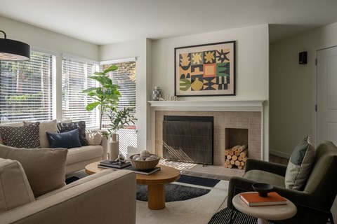 A living room with a fireplace and a painting above it.
