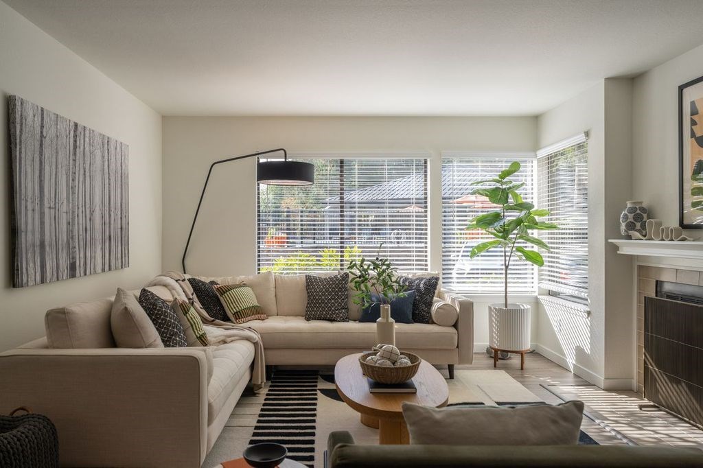 A living room with a couch, a table, and a fireplace.