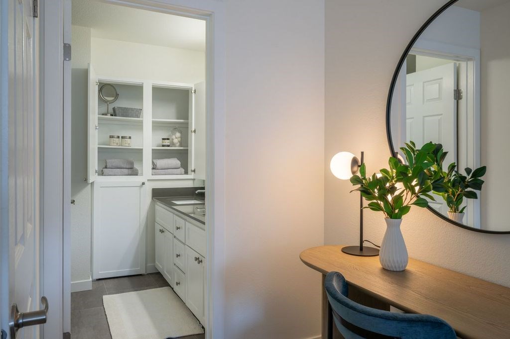 A bathroom with a sink, mirror, and a vanity with a cabinet and drawers.