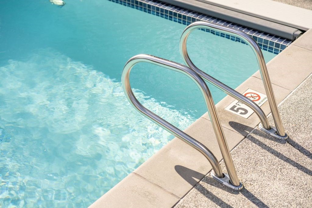 A pool ladder with a no-entry sign on it.