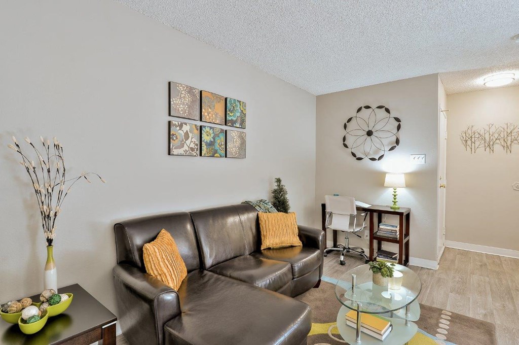 a living room with a leather couch and a glass table