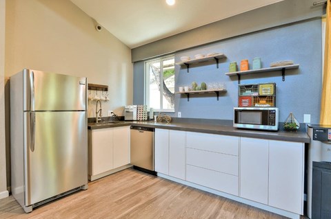 a kitchen with white cabinets and a stainless steel refrigerator