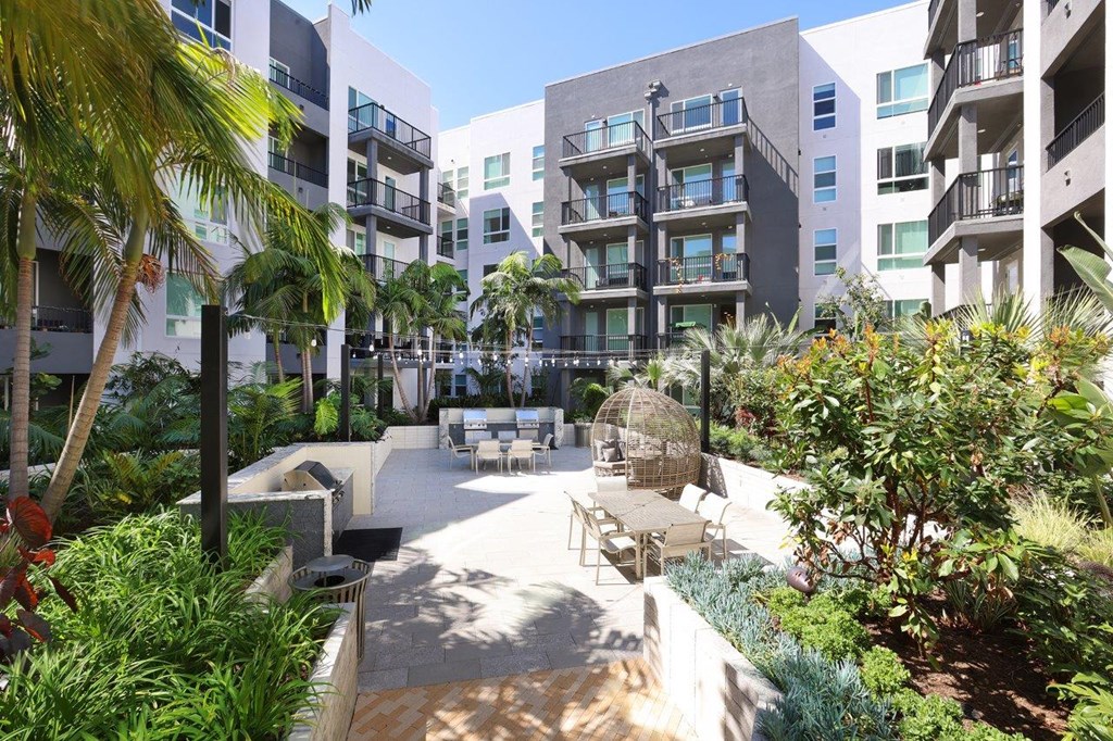 a courtyard with tables and chairs in an apartment building