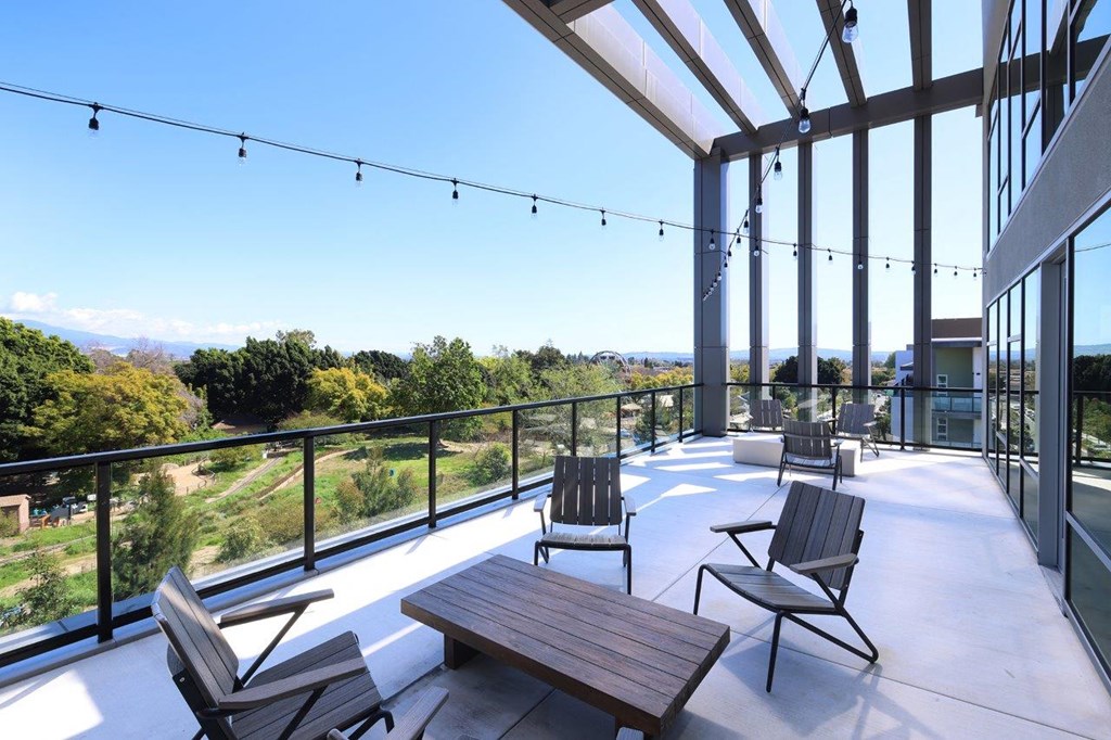 a patio with chairs and tables on a balcony
