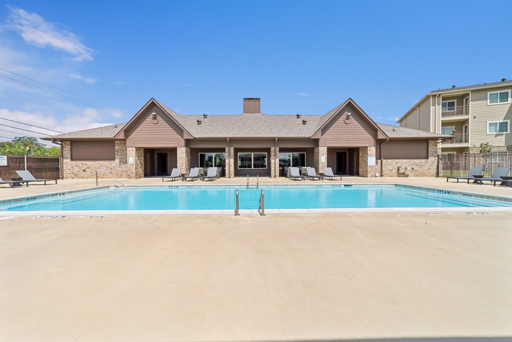 A large house with a pool in front.