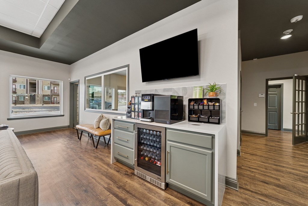 A modern living room with a grey cabinet and a flat screen TV mounted on the wall.