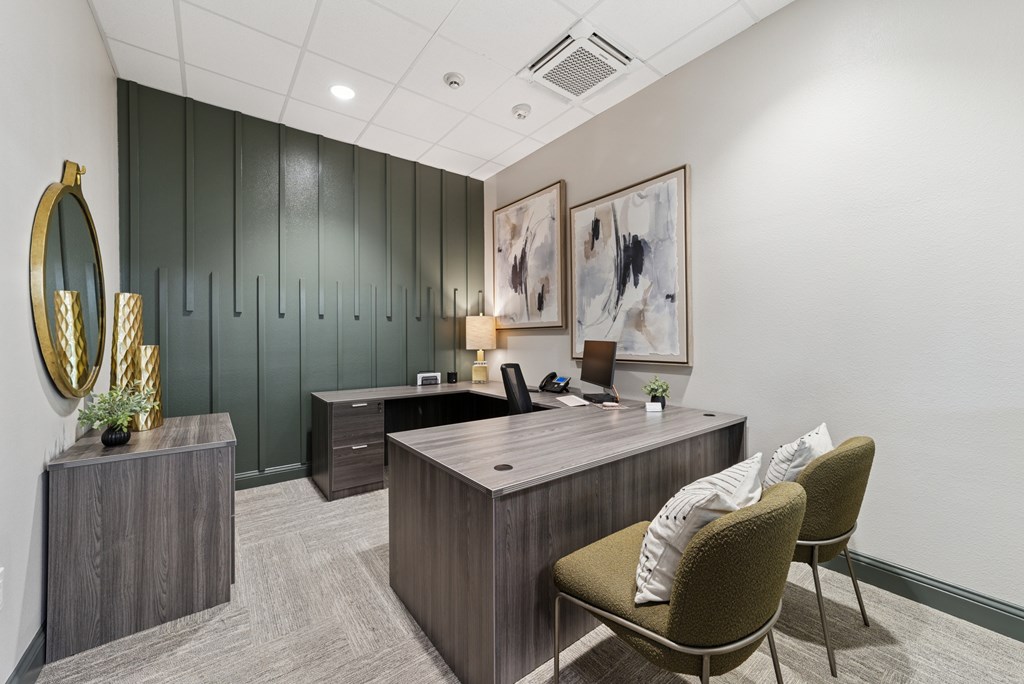 A modern office with a green wall and a wooden desk.