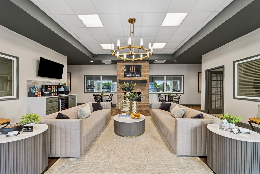 A modern living room with a fireplace and grey couches.