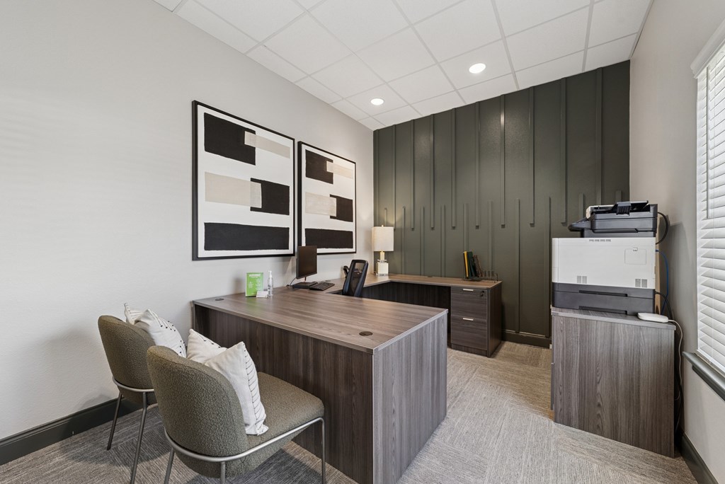 A modern office with a grey chair and a brown desk.