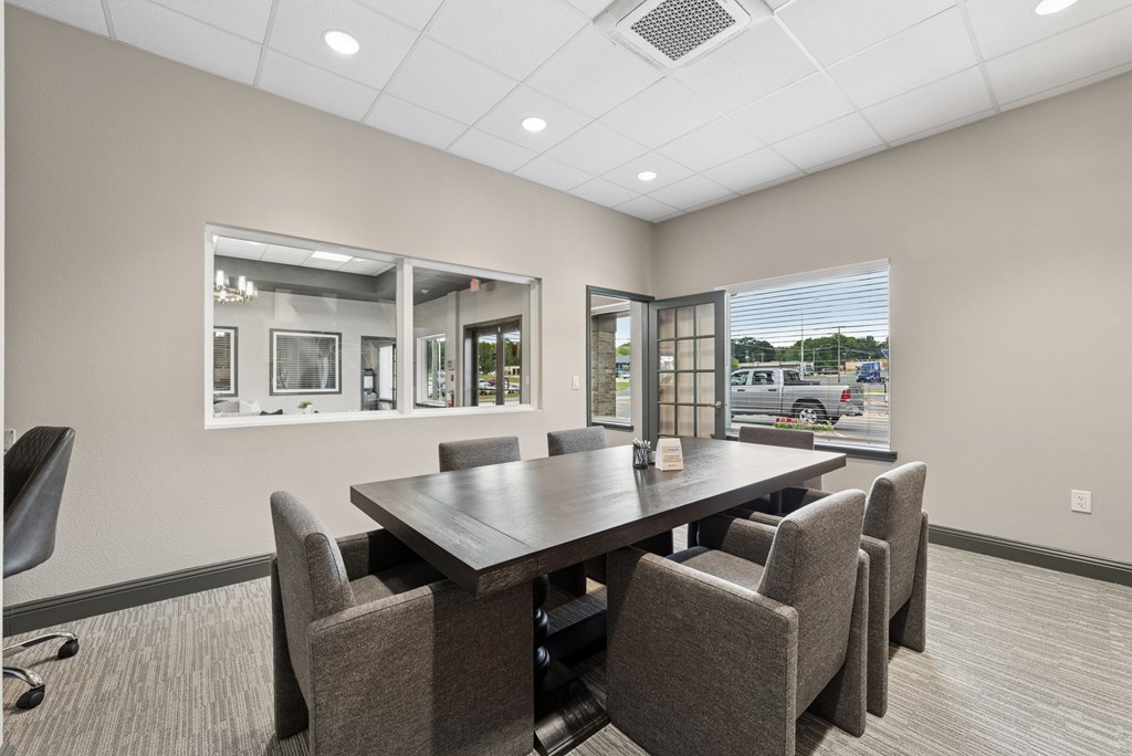 A conference room with a large table and chairs.