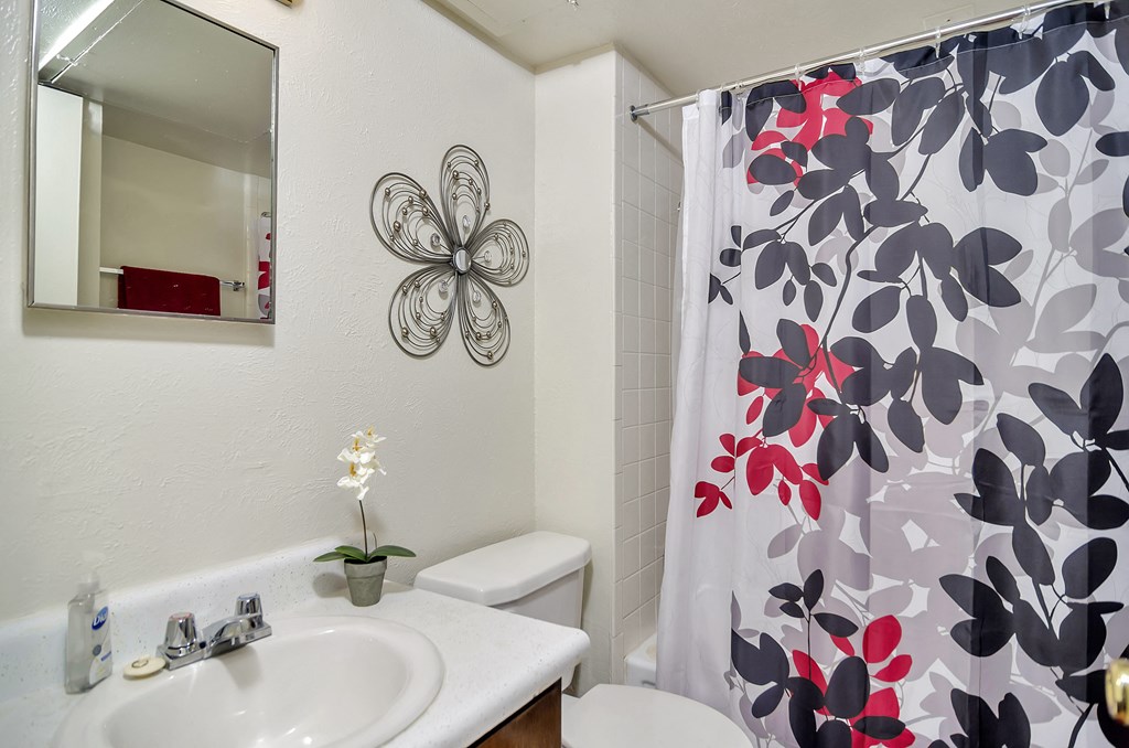 a bathroom with a shower curtain and a sink and a toilet