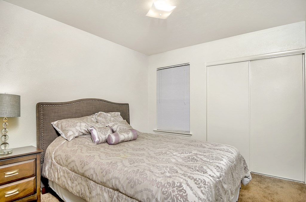 a bedroom with a bed and a dresser and a window