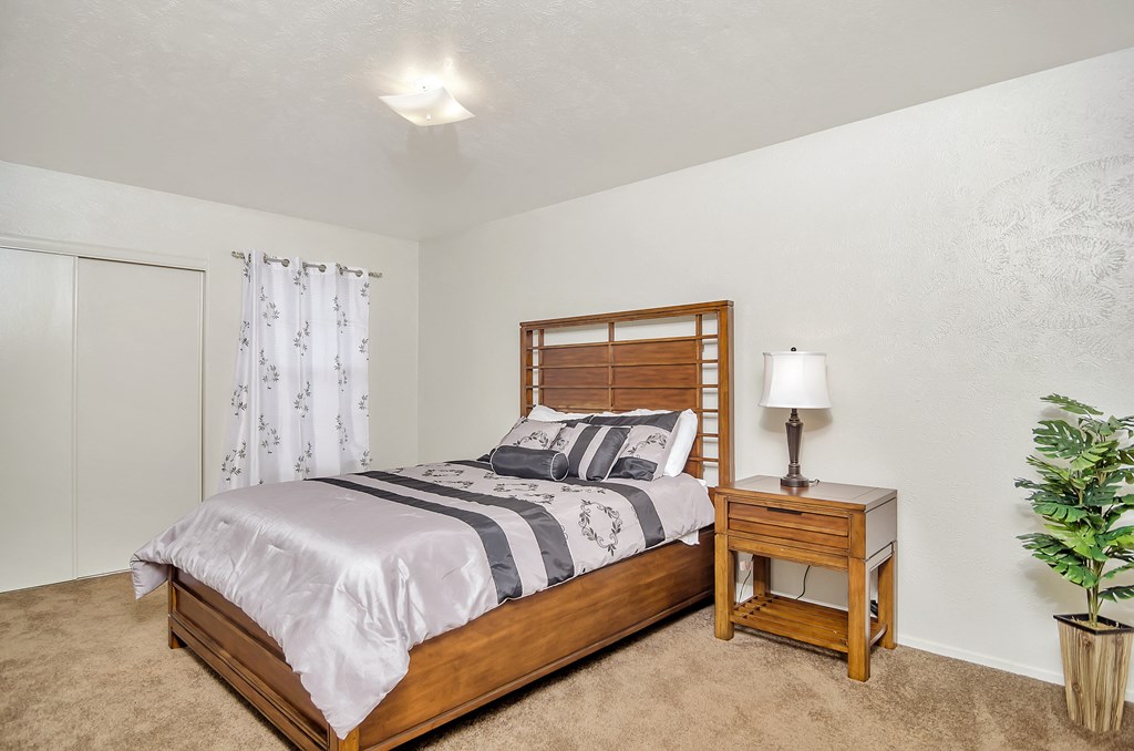 a bedroom with a bed and a night stand