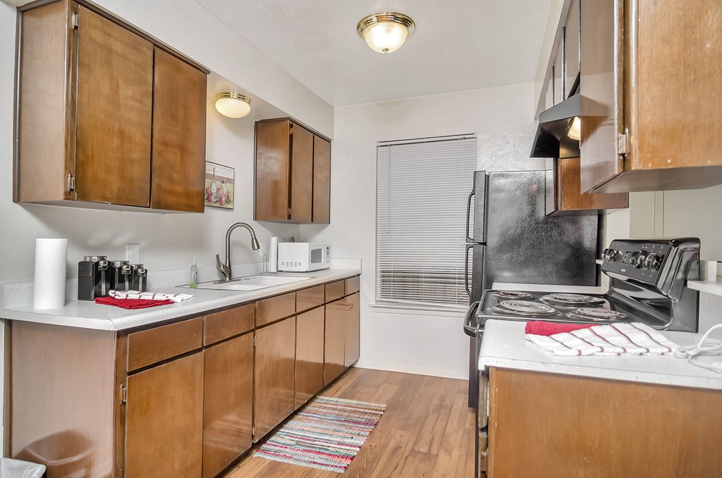 a kitchen with wooden cabinets and white counter tops and a stove and refrigerator
