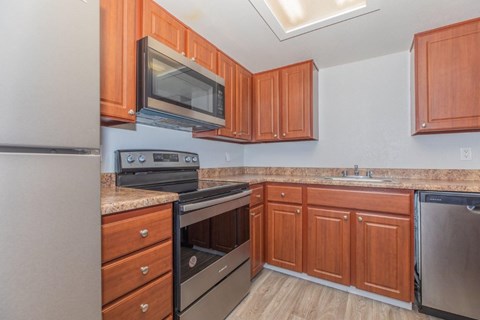 A kitchen with wooden cabinets and stainless steel appliances.