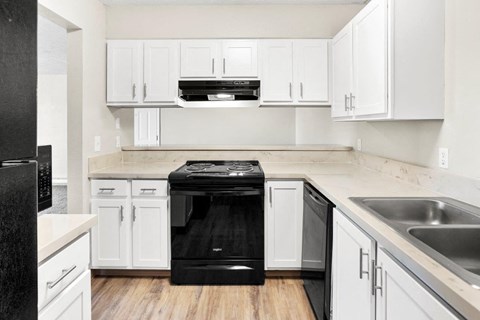 a kitchen with white cabinets and a black stove