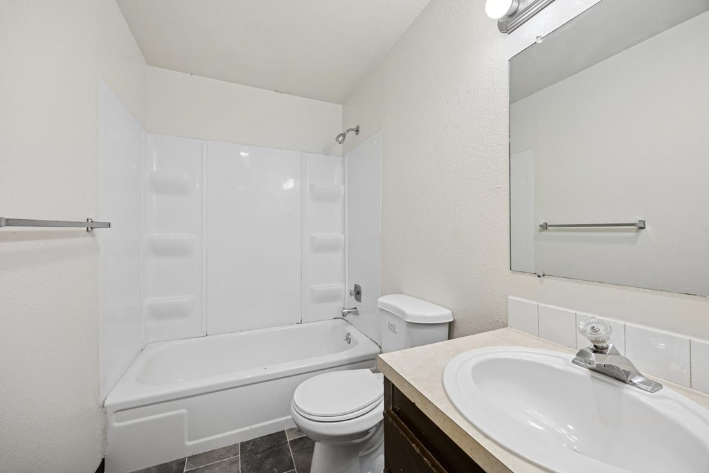 A white bathroom with a toilet, sink, and bathtub.