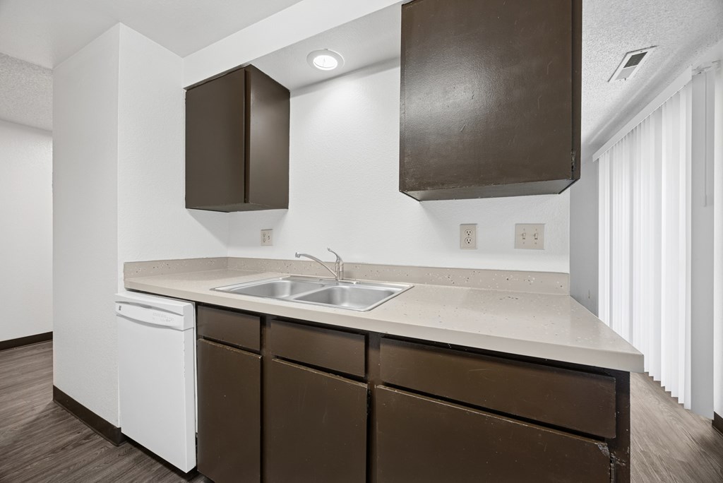 A kitchen with brown cabinets and white appliances.