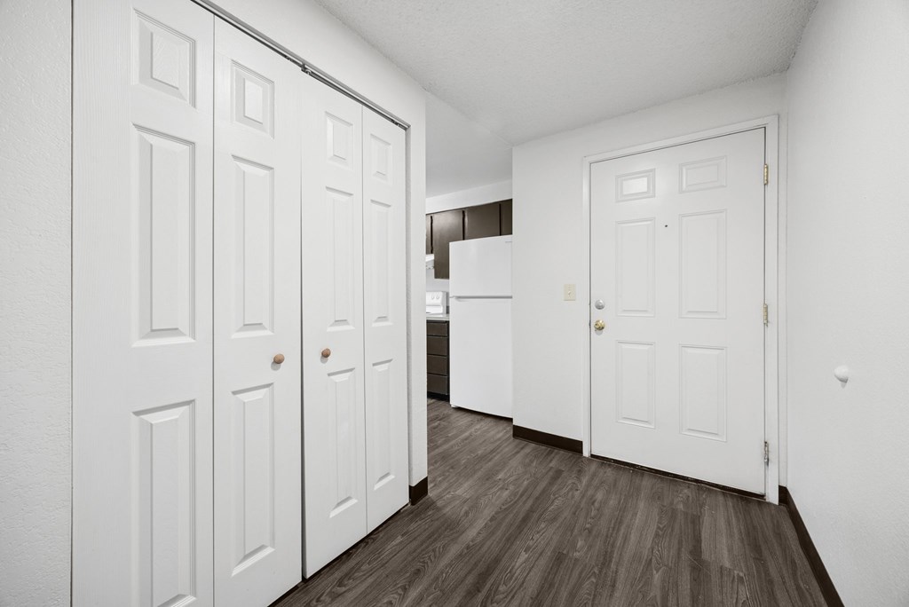 A hallway with white doors and a wooden floor.