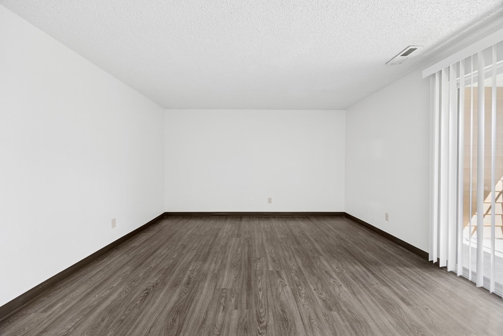 A room with wooden flooring and white walls.