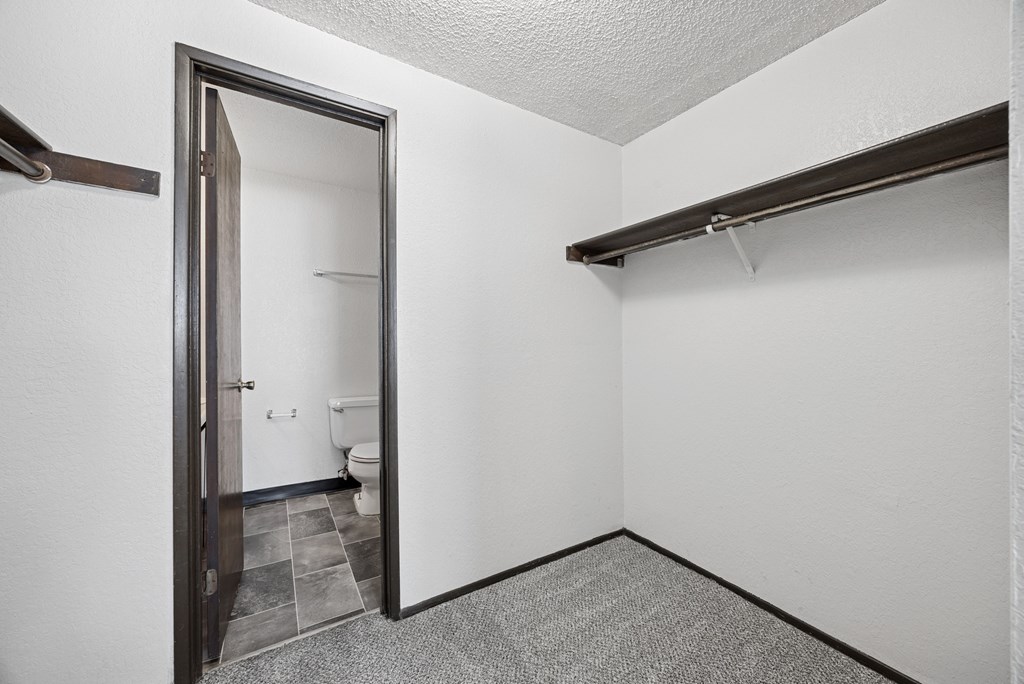 A bathroom with a toilet and sink is visible through an open door.
