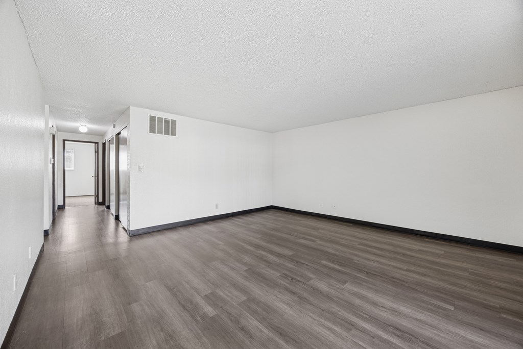 A room with wood flooring and white walls.
