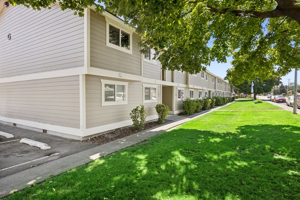 A row of houses with green lawns in front.