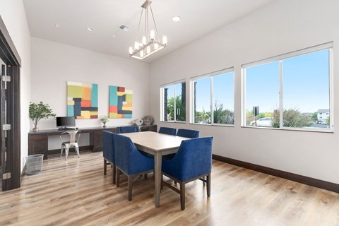 a dining room with a table and chairs and large windows