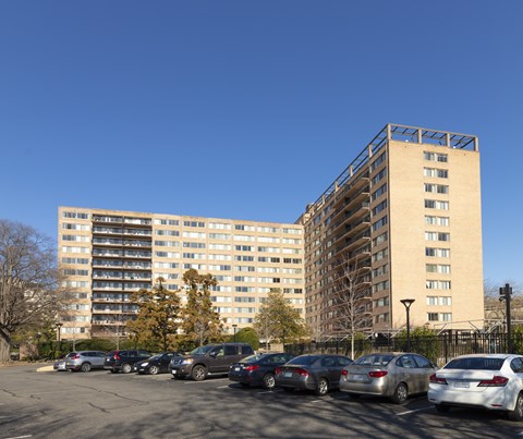 A parking lot with cars and apartment buildings in the background.