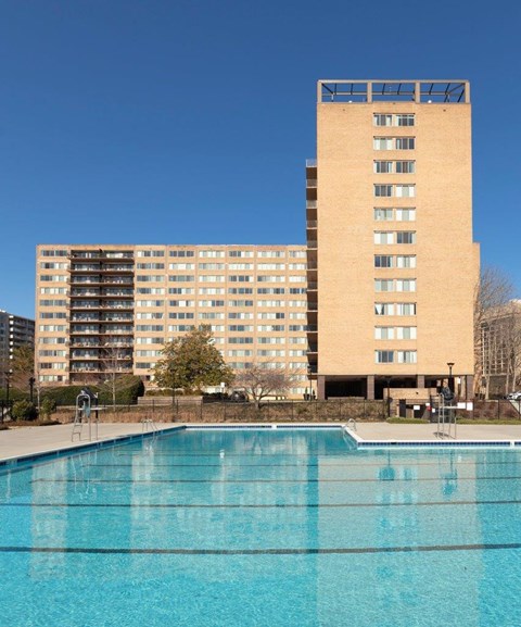 A large building with a pool in front of it.
