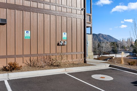 A parking lot with a building and a mountain in the background.