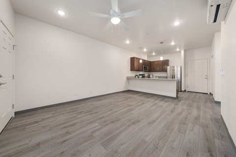 A spacious room with a ceiling fan and wooden flooring.
