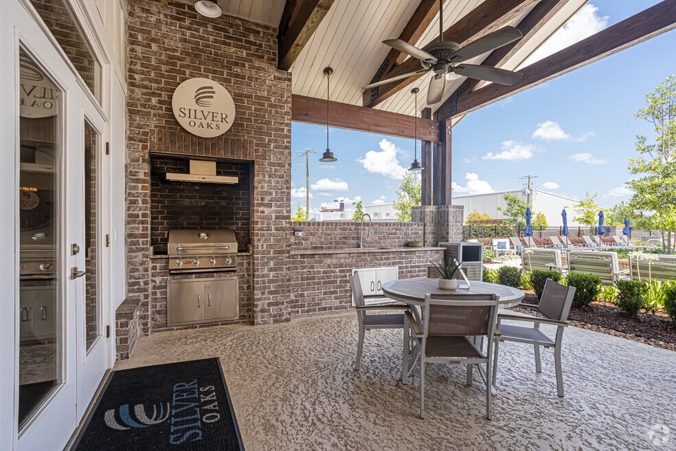a patio with a table and chairs and a grill