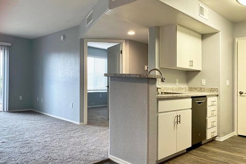 A kitchen with white cabinets and a granite countertop.