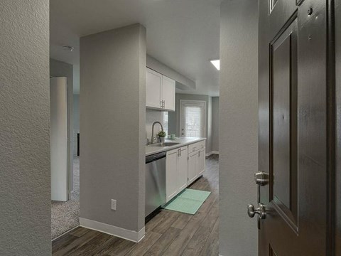 a kitchen with white cabinets and a sink and a door