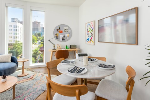 A dining room with a white table and chairs.