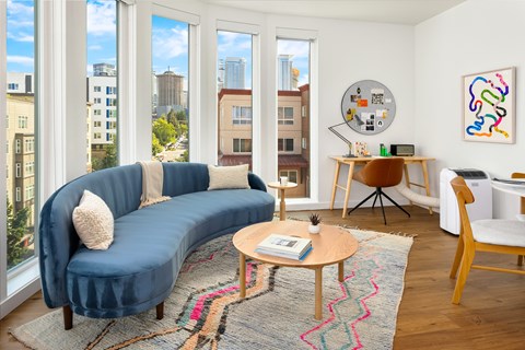 A living room with a blue couch and a wooden coffee table.