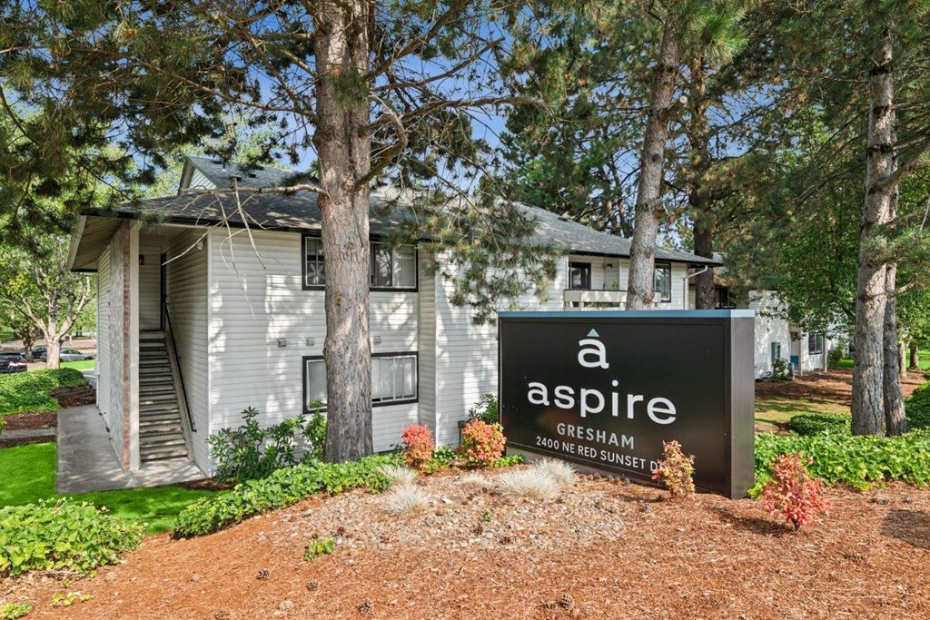 A sign for a place called Aspire is in front of a house.
