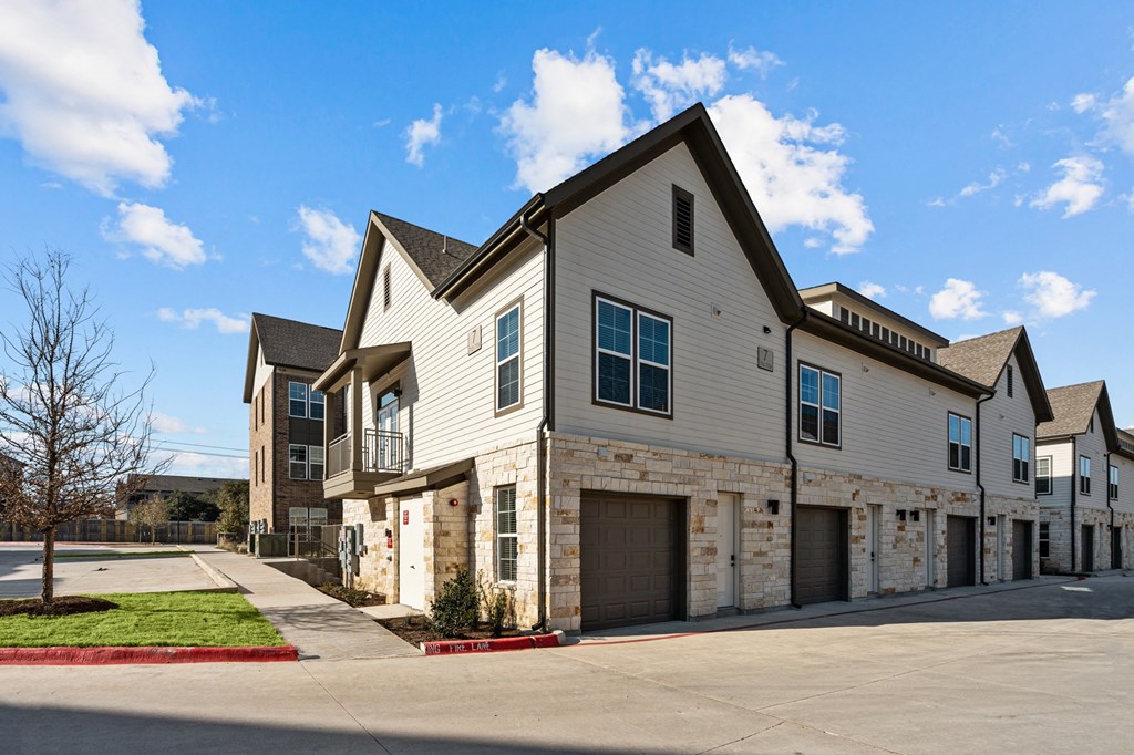 a house with a stone and white facade and a driveway at Lenox Grand, Austin