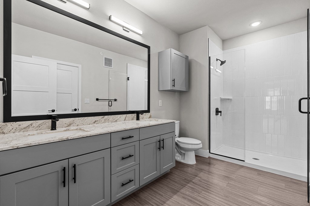 a bathroom with a large mirror and a toilet and a shower at Lenox Grand, Texas 
