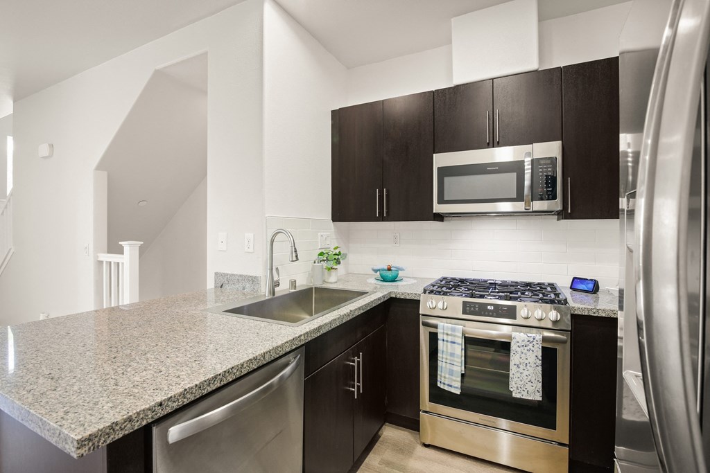 an apartment kitchen with stainless steel appliances and granite counter tops