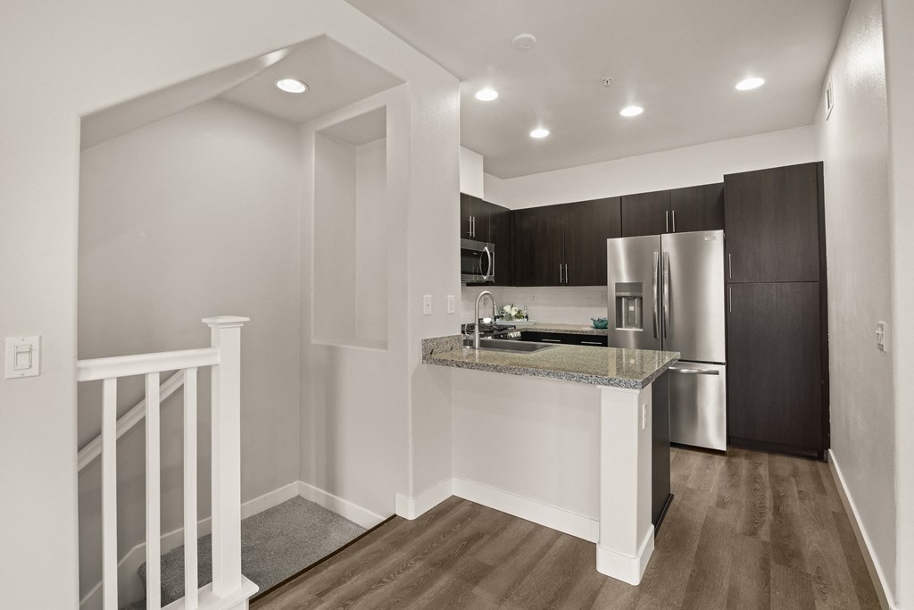 a kitchen with a granite counter top and a stainless steel refrigerator